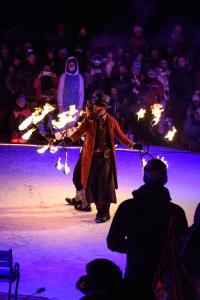 a man standing on a stage holding torches at ARC 1950 - Appartement 8 personnes Duplex Cheminée - ski aux pieds - Sauna, Hammam, Jacuzzi, Piscine in Arc 1950 +23 photos