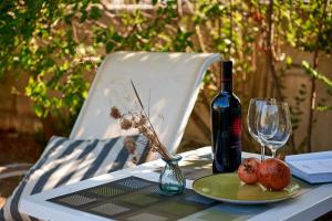 a table with a bottle of wine and a plate of fruit at Guest House Dima in Sozopol