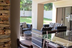 sala de estar con sillas y mesa de cristal en Angel Guest House en Johannesburgo