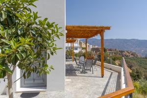 a balcony with chairs and a pergola at South Akro in Míthoi