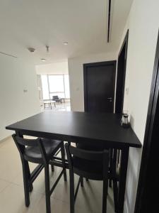 a black dining room table and chairs in a room at C-Suite Views at Al Reem and Al Maryah Island in Abu Dhabi