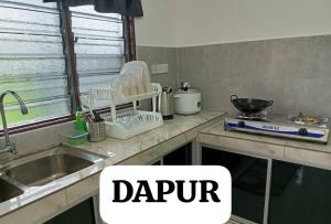 a kitchen with a sink and a counter top with the words darpur at SaFa HOMESTAY PULAU INDAH in Pulau Indah +10 photos