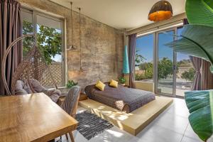 a bedroom with a bed in a room with a table at Gaia Blue Villa in Kolimbia +22 photos