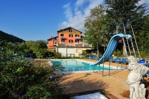 a swimming pool with a slide and a playground at Hotel Benessere Villa Fiorita in Colfiorito