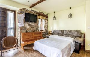 una sala de estar con una cama y un sofá en La Tienda de Abajo - Apartamentos acogedores con calefacción, parking y vistas al Valle de Soba, en Villar