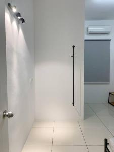 a white bathroom with a shower and a glass door at Boss Baby Cozy Holiday Home Batu Kawan in Ji Kongsi