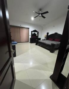 a living room with a bed and a ceiling fan at Casa vacacional in Isla La Piedra