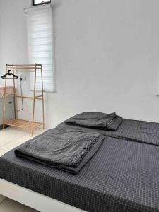 a bed with black sheets on it in a room at Boss Baby Cozy Holiday Home Batu Kawan in Ji Kongsi