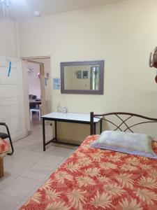 a bedroom with a bed with a desk and a mirror at La esquina in Monterrey