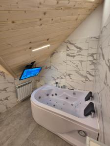 a bath tub in a bathroom with a wooden ceiling at Apartament z prywatną wanną z hydromasażem - U Parów in Białka Tatrzańska +172 photos