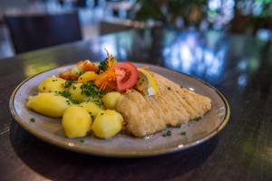 a plate of food with fish and vegetables on a table at Sportschule Oberhaching in Oberhaching