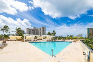 ホノルルにあるEntire condo in Waikiki - Ocean View 2 BR & 4 bedのヤシの木と建物が並ぶリゾートのプールを利用できます。