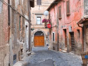 an alley with a stop sign and a wooden door at Holiday House Stella by Holiday World in Colle Farnese