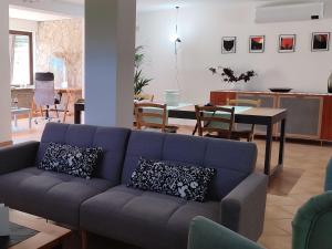 a living room with a blue couch and a dining room at Holiday House Stella by Holiday World in Colle Farnese