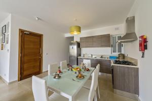 una cucina con tavolo e sedie in una cucina di Hillock Residence Apartments a Marsalforn