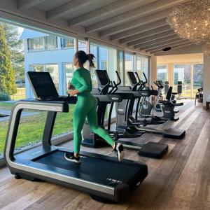 Una donna che corre su un tapis roulant in palestra di Parkhotel Delta, Wellbeing Resort ad Ascona