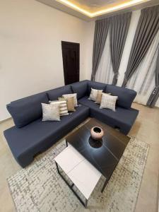 a blue couch in a living room with a table at Luxury 2 bed 2bath East Legon in Madina