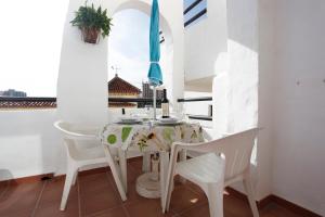 een witte eetkamer met een tafel en stoelen bij Benalmadenapartments BBQ Evita Beach Club in Benalmádena