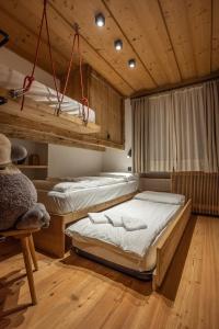 2 letti a castello in una camera con soffitti in legno di Casa dell Alpinista a Cortina d Ampezzo a Cortina dʼAmpezzo