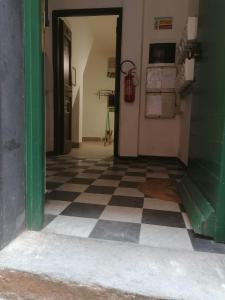 an empty hallway with a checkered floor in a building at Casa Bartelli in Finale Ligure +19 photos