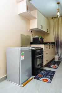 una cocina con refrigerador y estufa en graryshome, en Kiambu