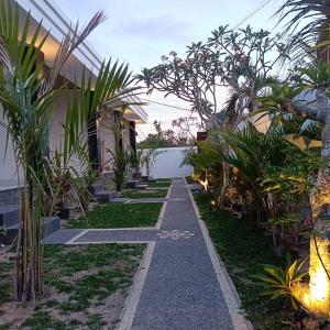 a walkway through a garden with plants at Prayoga homestay in Nusa Dua