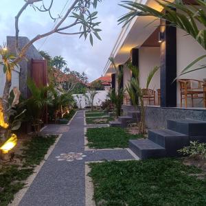 a walkway in front of a house with plants at Prayoga homestay in Nusa Dua