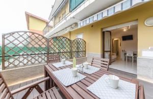 a balcony with a wooden table and chairs at Residence Daytona Appartamento due camere in Caorle