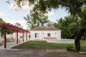 Un patio trasero de una casa blanca con piscina. en Herdade do Peru Casa dos Netos, en Azeitão