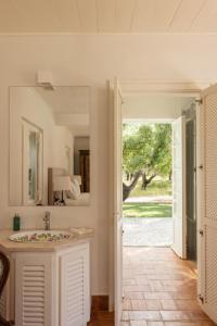 Un baño con lavabo y puerta a un patio en Herdade do Peru Casa dos Netos, en Azeitão