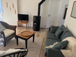 a living room with a couch and a stove at maison 6-8 personnes, 300m de la plage in La Guérinière