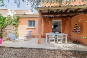 a patio with a table and chairs and an umbrella at Jaso - Maison à 5min de la plage in Cervione