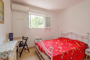 a bedroom with a bed and a table and a window at Jaso - Maison à 5min de la plage in Cervione +6 photos