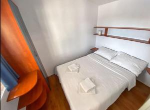 a small bedroom with a white bed with two white pillows at Mobilheim Camping 6 Personen Pool am Meer in Turanj