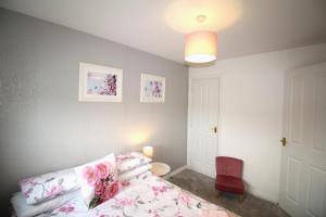 una camera da letto con un letto e una sedia rossa di 2 Bed House - Large Garden - Pet Friendly a Ashington