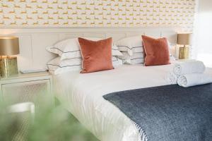 a bedroom with a white bed with pillows at Linhay Cottages 1 in Bathford
