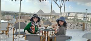 Due donne sedute a un tavolo sul balcone di Topview Pyramids And Museum a Il Cairo
