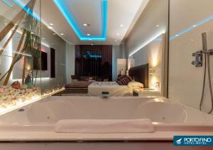 a large bath tub in a room with a bedroom at Motel Portofino in Matosinhos +77 photos