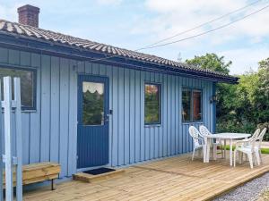 een blauw huis met een tafel en stoelen op een terras bij 4 person holiday home in KÖPINGSVIK-By Traum in Köpingsvik