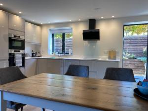 a kitchen with a wooden table and chairs at Linhay Cottages 1 in Bathford