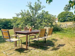 a wooden table with three chairs sitting around it at 8 person holiday home in GOTLANDS TOFTA in Västergarn
