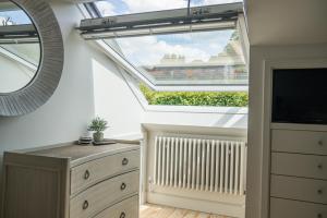 a skylight in a room with a radiator and a window at Linhay Cottages 2 in Bathford