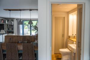 a kitchen and dining room with a table and a toilet at Linhay Cottages 2 in Bathford +37 photos
