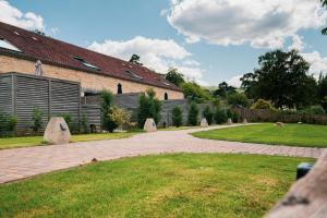 a brick building with a brick walkway next to a yard at Linhay Cottages 2 in Bathford