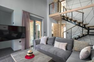 a living room with a gray couch and a tv at Luxury villa in Lachania near sea in Lachania