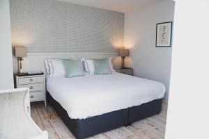 a bedroom with a large white bed with two night stands at Linhay Cottages 3 in Bathford