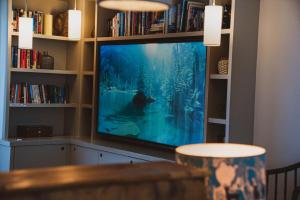 a large flat screen tv sitting in a book shelf at Linhay Cottages 3 in Bathford