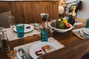 a wooden table with a plate of food and wine glasses at Linhay Cottages 3 in Bathford