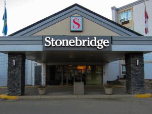 una tienda con un cartel en la parte delantera de un edificio en Stonebridge Hotel, en Fort McMurray
