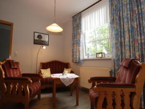 a room with chairs and a table and a window at Reihenhaus in Strackholt mit beheiztem Pool in Strackholt